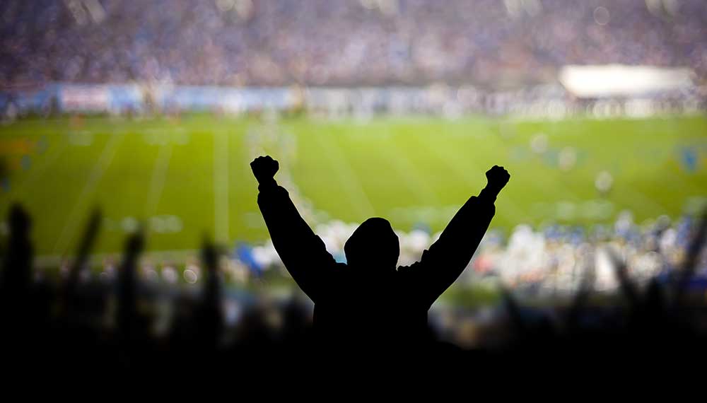 Fan cheering at a football stadium