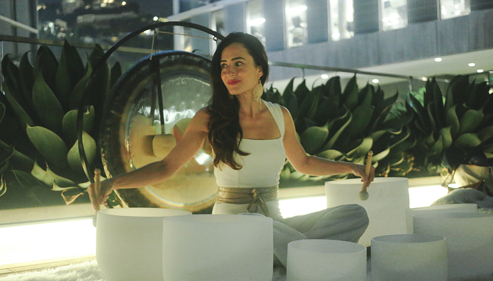 woman sitting with bowls of sound healing
